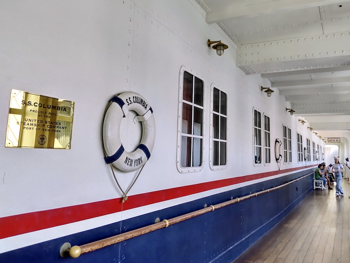 A hallway inside the S.S. Columbia with golden nameplates mounted on the wall