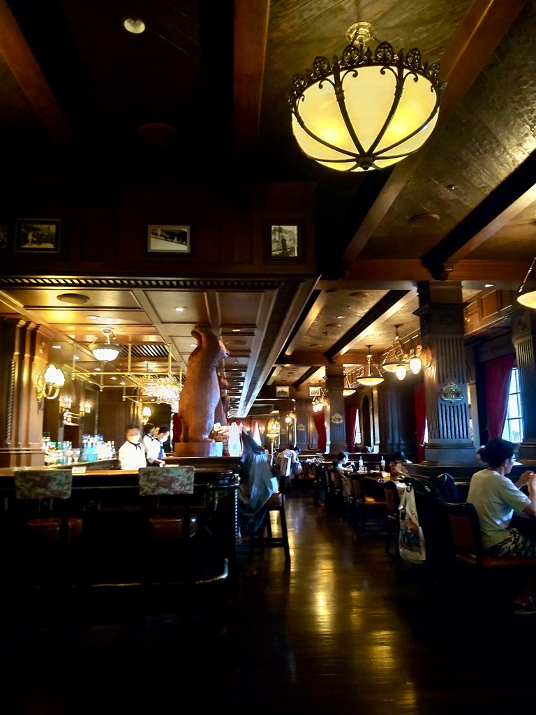The dimly lit interior of the Teddy Roosevelt Lounge inside the S.S. Columbia, featuring a prominent wooden bar counter